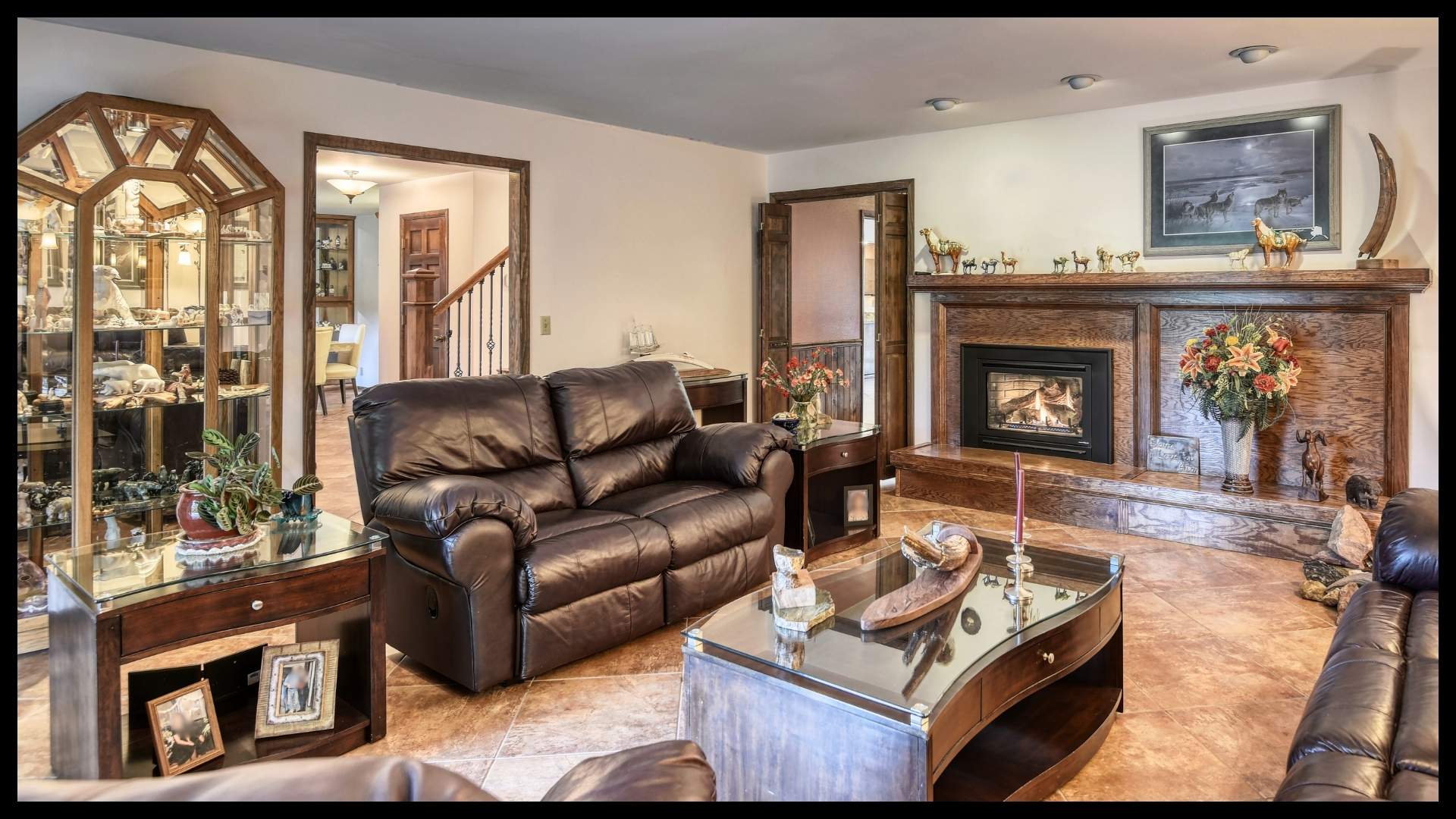 cozy living room with leather sofas, wood fireplace mantel, and decorative accents in a spacious North Idaho ranch home